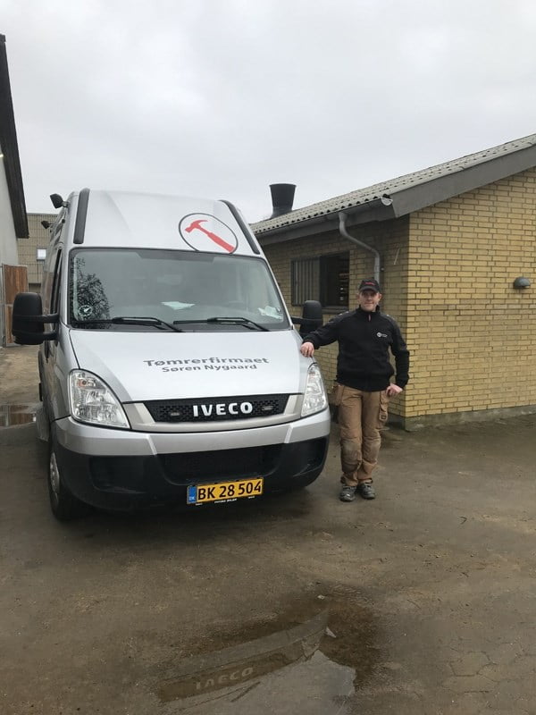 Tømrer foran Iveco firmabil udenfor bygning