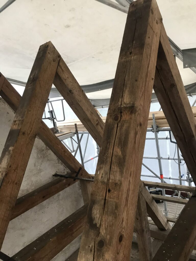Trækonstruktion under tagrenovering med stillads
