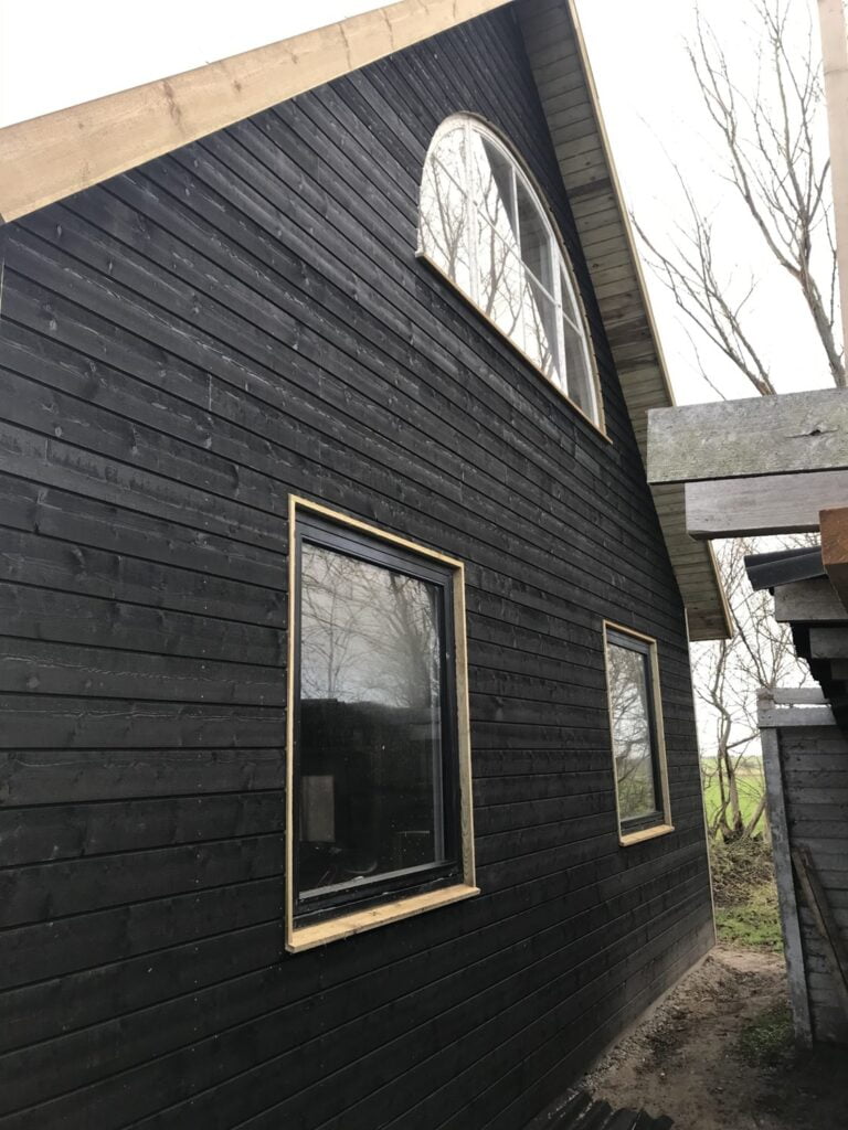 Sort træhus med store vinduer