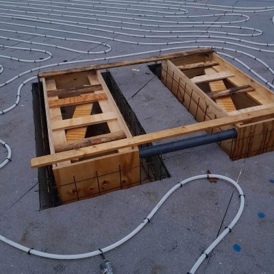 Gulvvarmerør installeret i betonfundament under konstruktion